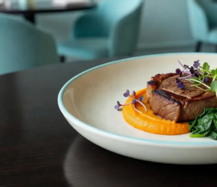 Servírovaný hlavní chod ve stylové restauraci